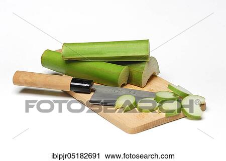Stock Image - Taroleaf stalks and knives, chopping board, carrot root, coco-yam (Colocasia esculenta) Kalo, Taioba, Eddo, Eddoe, Eddro, Dasheen. Fotosearch