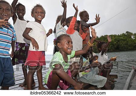 Stock Image - Telina Island locals greet visitors, Marovo Lagoon, Solomon Islands, Oceania. Fotosearch