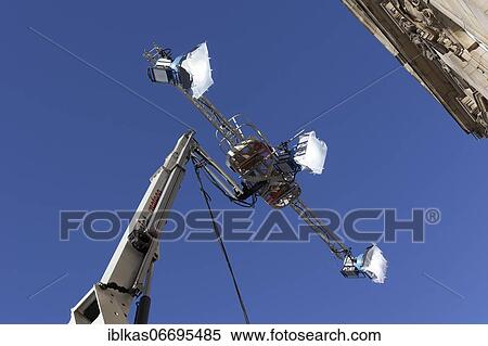 Stock Photography - Three spotlights in front of a blue sky, mounted on a working stage, Filmlicht, Düsseldorf, North Rhine-Westphalia, Germany, Europe. Fotosearch