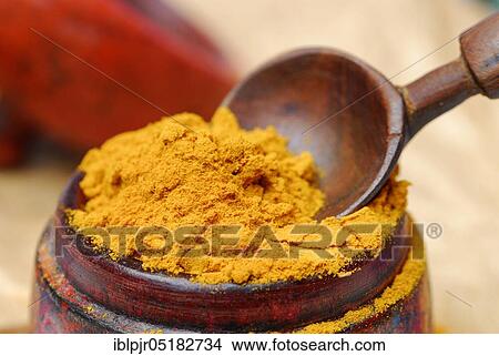 Picture - Turmericpowder (Curcuma longa) and spoon. Fotosearch