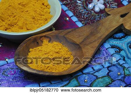 Stock Image - Turmericpowder (Curcuma longa) and spoon. Fotosearch