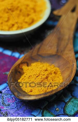 Stock Image - Turmericpowder (Curcuma longa) and spoon. Fotosearch