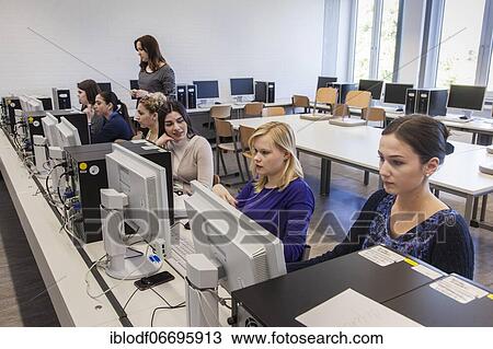 Stock Image - Vocational school students in class at the computer. Dual system at the Elly-Heuss-Knapp-Schule, a vocational college of the city of Düsseldorf, North Rhine-Westphalia, Germany, Europe. Fotosearch