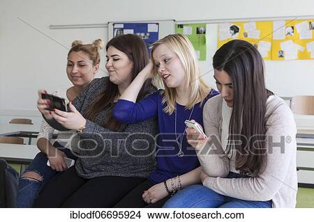 Picture - Vocational school students with their smartphones during break at the Elly-Heuss-Knapp-Schule, a vocational college of the city of Düsseldorf, North Rhine-Westphalia, Germany, Europe. Fotosearch