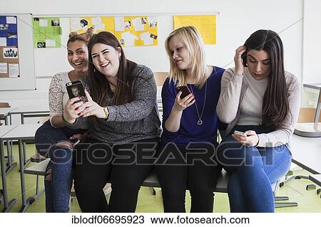 Vocational school students with their smartphones during break at the Elly-Heuss-Knapp-Schule, a vocational college of the city of Düsseldorf, North Rhine-Westphalia, Germany, Europe View Large Photo Image Stock Image - Vocational school students with their smartphones during break at the Elly-Heuss-Knapp-Schule, a vocational college of the city of Düsseldorf, North Rhine-Westphalia, Germany, Europe. Fotosearch