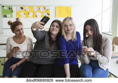 Stock Photo - Vocational school students with their smartphones during break at the Elly-Heuss-Knapp-Schule, a vocational college of the city of Düsseldorf, North Rhine-Westphalia, Germany, Europe. Fotosearch