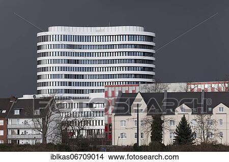 White office tower by SOP Architekten, Trivago Tower, old residential buildings in front, stormy sky, Düsseldorf Media Harbour, Düsseldorf, North Rhine-Westphalia, Germany, Europe View Large Photo Image Picture - White office tower by SOP Architekten, Trivago Tower, old residential buildings in front, stormy sky, Düsseldorf Media Harbour, Düsseldorf, North Rhine-Westphalia, Germany, Europe. Fotosearch