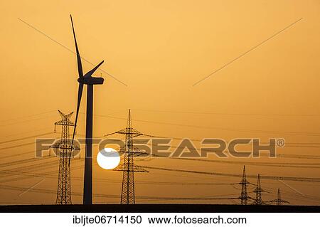 Wind turbine and power pole at sunset, Niederaussem, North Rhine-Westphalia, Germany, Europe View Large Photo Image Stock Image - Wind turbine and power pole at sunset, Niederaussem, North Rhine-Westphalia, Germany, Europe. Fotosearch