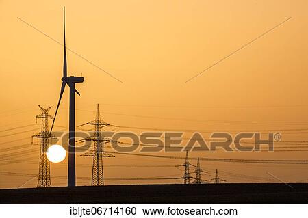 Wind turbine and power pole at sunset, Niederaussem, North Rhine-Westphalia, Germany, Europe View Large Photo Image Stock Image - Wind turbine and power pole at sunset, Niederaussem, North Rhine-Westphalia, Germany, Europe. Fotosearch