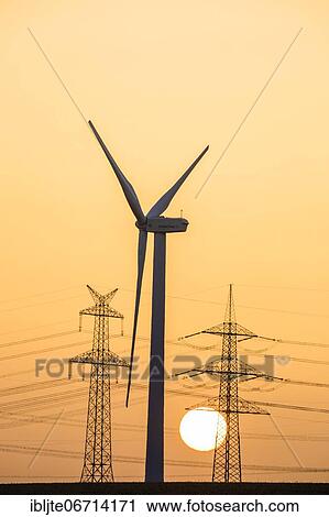 Wind turbine and power pole at sunset, Niederaussem, North Rhine-Westphalia, Germany, Europe View Large Photo Image Stock Image - Wind turbine and power pole at sunset, Niederaussem, North Rhine-Westphalia, Germany, Europe. Fotosearch