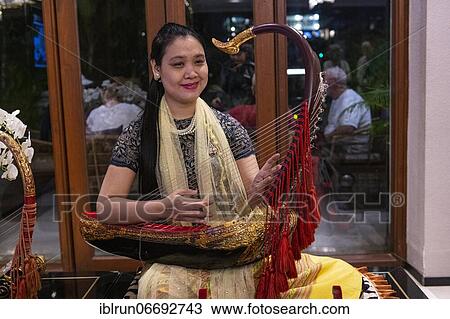 Woman playing a harp like instrument, Yangon, Myanmar, Asia View Large Photo Image Stock Image - Woman playing a harp like instrument, Yangon, Myanmar, Asia. Fotosearch