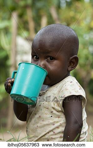 Young child drinking fresh milk from cup, Uganda, Africa View Large Photo Image Stock Image - Young child drinking fresh milk from cup, Uganda, Africa. Fotosearch