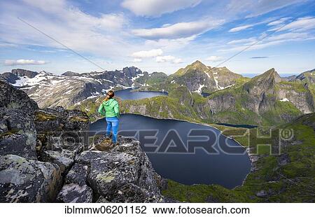 Young woman looking over mountain landscape with lake Tennesvatnet and Krokvatnet, view from the top of Munken, Moskenesöy, Lofoten, Nordland, Norway, Europe View Large Photo Image Stock Image - Young woman looking over mountain landscape with lake Tennesvatnet and Krokvatnet, view from the top of Munken, Moskenesöy, Lofoten, Nordland, Norway, Europe. Fotosearch