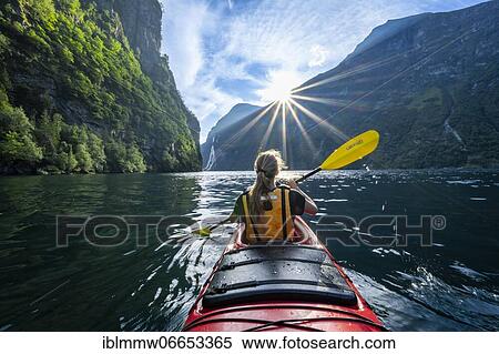 Stock Photography - Young woman paddling in a kayak, Geirangerfjord, near Geiranger, Norway, Europe. Fotosearch