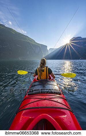 Stock Photo - Young woman paddling in a kayak, sun shining, Geirangerfjord, near Geiranger, Norway, Europe. Fotosearch