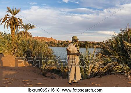 Beduin at the shore of Ounianga kebir part of the the Unesco sight Ounianga lakes, northern Chad, Africa View Large Photo Image Stock Photo - Beduin at the shore of Ounianga kebir part of the the Unesco sight Ounianga lakes, northern Chad, Africa. Fotosearch