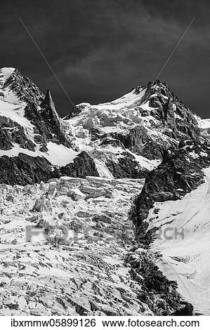 Stock Photograph - Black and white, La Jonction, glacier tongue, Glacier des Bossons meets Glacier de Taconnaz, summit of Mont Maudit, Mont Blanc and Aiguille de Bionnassay, Chamonix, Haute-Savoie, France, Europe. Fotosearch