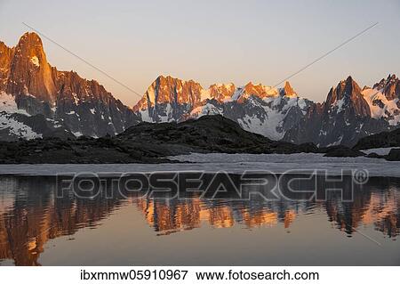 Evening atmosphere with alpenglow, water reflection in Lac Blanc, mountain peaks, Aiguille Verte, Grandes Jorasses, Aiguille du Moine, Mont Blanc, Mont Blanc massif, Chamonix-Mont-Blanc, Haute-Savoie, France, Europe View Large Photo Image Stock Photo - Evening atmosphere with alpenglow, water reflection in Lac Blanc, mountain peaks, Aiguille Verte, Grandes Jorasses, Aiguille du Moine, Mont Blanc, Mont Blanc massif, Chamonix-Mont-Blanc, Haute-Savoie, France, Europe. Fotosearch