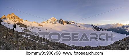 Stock Photo - Evening mood, Mountain panorama, Hiker standing in front of glacier, Glacier du Tour, Glacier and mountain peaks, High alpine landscape, Tête Blanche, Petite and Grande Fourche on the left, Alguille de Chardonnet, Chamonix, Haute-Savoie, France on the.... Fotosearch