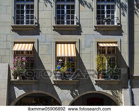 Stock Image - Facade of a house, windows with flower pots and awnings, Bernese Old Town, Inner City, Bern, Canton of Bern, Switzerland, Europe. Fotosearch