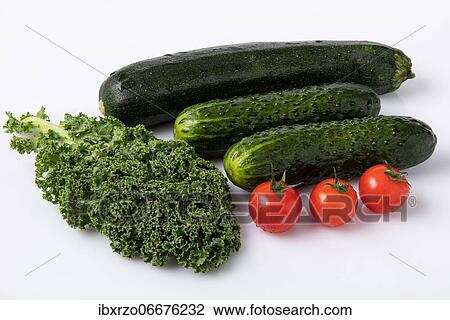Stock Image - Fresh garden vegetables with water drops, courgettes, tomatoes, garden cucumber, kale. Fotosearch