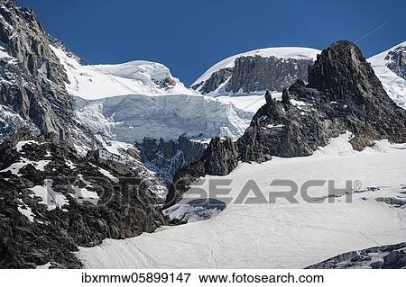 Stock Photo - High alpine mountain landscape, Refuge des Grands Mulets, mountain hut above La Jonction, glacier tongue, Glacier des Bossons, behind Mont Blanc, Chamonix, Haute-Savoie, France, Europe. Fotosearch