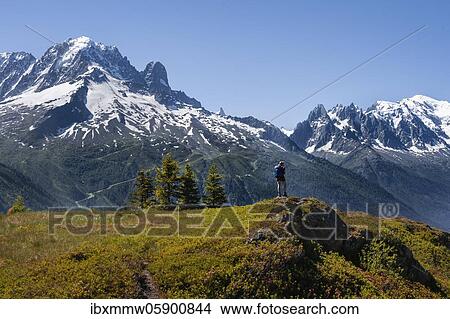 Hiker looking at mountain panorama from Aiguillette des Posettes, summit of Aiguille Verte, Aiguille du Midi and Mont Blanc, Chamonix, Haute-Savoie, France, Europe View Large Photo Image Picture - Hiker looking at mountain panorama from Aiguillette des Posettes, summit of Aiguille Verte, Aiguille du Midi and Mont Blanc, Chamonix, Haute-Savoie, France, Europe. Fotosearch