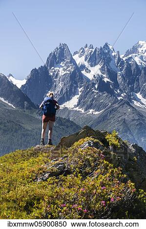 Stock Image - Hiker looking at mountain panorama from Aiguillette des Posettes, Aiguille du Midi, Chamonix, Haute-Savoie, France, Europe. Fotosearch