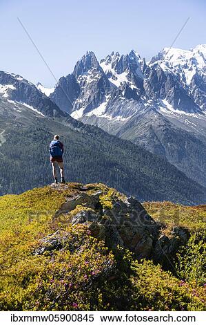 Stock Photography - Hiker looking at mountain panorama from Aiguillette des Posettes, Aiguille du Midi and Mont Blanc, Chamonix, Haute-Savoie, France, Europe. Fotosearch