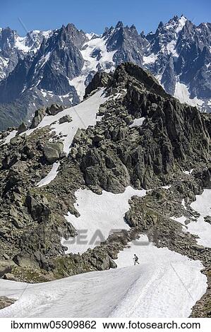 Stock Image - Hiker on snowfield, Aiguille Pourrie, back mountain peak of Mont Blanc massif, Chamonix-Mont-Blanc, Haute-Savoie, France, Europe. Fotosearch
