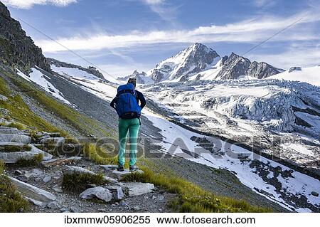 Stock Photography - Hiker on trail to Glacier du Tour, glacier and mountain peak, high alpine landscape, Aiguille de Chardonnet, Chamonix, Haute-Savoie, France, Europe. Fotosearch