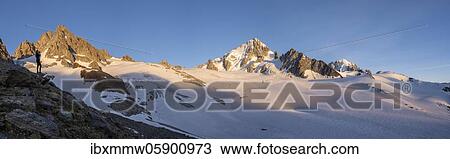 Stock Image - Hiker photographs mountain panorama, Glacier du Tour, glaciers and mountain peaks, high alpine landscape, Alguille de Chardonnet, Chamonix, Haute-Savoie, France, Europe. Fotosearch