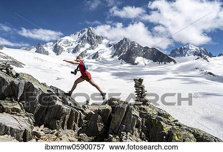 Stock Photo - Hiker sprinting over rocks, Glacier du Tour, glacier and mountain peaks, high alpine landscape, left Aiguille du Chardonnet, Chamonix, Haute-Savoie, France, Europe. Fotosearch