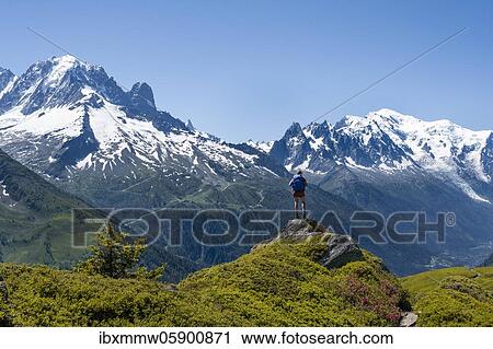Hiker standing on rocks, mountain panorama from Aiguillette des Posettes, left summit of Aiguille Verte (right) Aiguille du Midi and Mont Blanc, Chamonix, Haute-Savoie, France, Europe View Large Photo Image Stock Image - Hiker standing on rocks, mountain panorama from Aiguillette des Posettes, left summit of Aiguille Verte (right) Aiguille du Midi and Mont Blanc, Chamonix, Haute-Savoie, France, Europe. Fotosearch