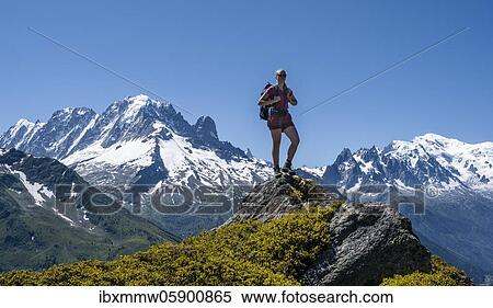 Hiker standing on rocks, mountain panorama from Aiguillette des Posettes, left summit of Aiguille Verte (right) Aiguille du Midi and Mont Blanc, Chamonix, Haute-Savoie, France, Europe View Large Photo Image Stock Photography - Hiker standing on rocks, mountain panorama from Aiguillette des Posettes, left summit of Aiguille Verte (right) Aiguille du Midi and Mont Blanc, Chamonix, Haute-Savoie, France, Europe. Fotosearch