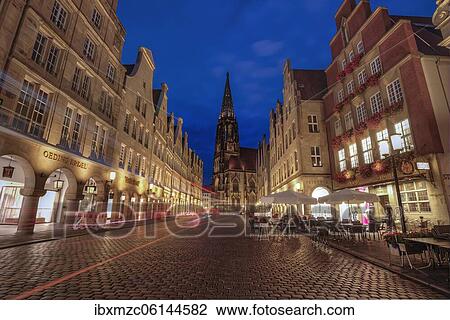 Stock Image - Illuminated historic gabled houses with St Lamberti Church, in the evening at blue hour, Prinzipalmarkt, Münster, North Rhine-Westphalia, Germany, Europe. Fotosearch