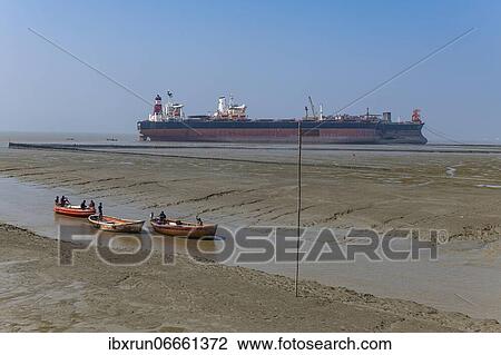 Stock Image - Little fishing boats in the low tide, Chittagong Ship Breaking Yard, Chittagong, Bangladesh, Asia. Fotosearch
