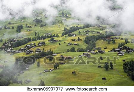 Many houses on meadows on mountain slope in fog, view of Grindelwald, Bernese Oberland, Switzerland, Europe View Large Photo Image Stock Photo - Many houses on meadows on mountain slope in fog, view of Grindelwald, Bernese Oberland, Switzerland, Europe. Fotosearch
