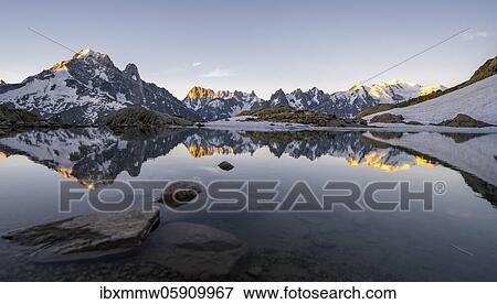 Morning atmosphere at sunrise, water reflection in Lac Blanc, mountain top, Aiguille Verte, Grandes Jorasses, Aiguille du Moine, Mont Blanc, Mont Blanc massif, Chamonix-Mont-Blanc, Haute-Savoie, France, Europe View Large Photo Image Stock Photo - Morning atmosphere at sunrise, water reflection in Lac Blanc, mountain top, Aiguille Verte, Grandes Jorasses, Aiguille du Moine, Mont Blanc, Mont Blanc massif, Chamonix-Mont-Blanc, Haute-Savoie, France, Europe. Fotosearch