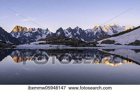 Stock Photo - Morning atmosphere at sunrise, water reflection in Lac Blanc, mountain top, Aiguille Verte, Grandes Jorasses, Aiguille du Moine, Mont Blanc, Mont Blanc massif, Chamonix-Mont-Blanc, Haute-Savoie, France, Europe. Fotosearch
