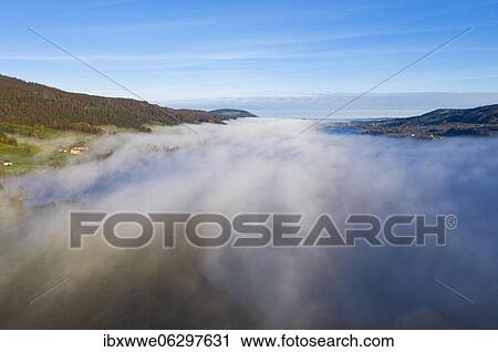 Morning fog at Irrsee, inversion weather, drone photo, aerial photo, Zell am moss, Mondseeland, Salzkammergut, Upper Austria, Austria, Europe View Large Photo Image Stock Image - Morning fog at Irrsee, inversion weather, drone photo, aerial photo, Zell am moss, Mondseeland, Salzkammergut, Upper Austria, Austria, Europe. Fotosearch