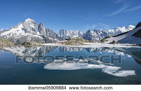 Picture - Mountain panorama, ice floe on Lac Blanc, mountain peaks reflected in mountain lake, Grandes Jorasses and Mont Blanc massif, Chamonix-Mont-Blanc, Haute-Savoie, France, Europe. Fotosearch
