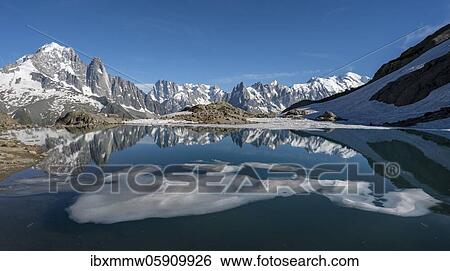 Stock Photograph - Mountain panorama, ice floe on Lac Blanc, mountain peaks reflected in mountain lake, Grandes Jorasses and Mont Blanc massif, Chamonix-Mont-Blanc, Haute-Savoie, France, Europe. Fotosearch