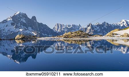 Mountain panorama with water reflection in Lac Blanc, mountain tops, Aiguille Verte, Grandes Jorasses, Aiguille du Moine, Mont Blanc, Mont Blanc massif, Chamonix-Mont-Blanc, Haute-Savoie, France, Europe View Large Photo Image Stock Image - Mountain panorama with water reflection in Lac Blanc, mountain tops, Aiguille Verte, Grandes Jorasses, Aiguille du Moine, Mont Blanc, Mont Blanc massif, Chamonix-Mont-Blanc, Haute-Savoie, France, Europe. Fotosearch