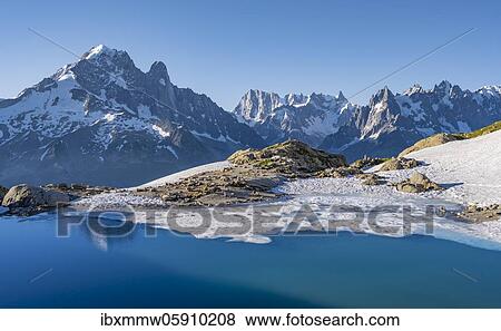 Stock Photo - Mountain panorama with water reflection in Lac Blanc, mountain tops, Aiguille Verte, Grandes Jorasses, Aiguille du Moine, Mont Blanc, Mont Blanc massif, Chamonix-Mont-Blanc, Haute-Savoie, France, Europe. Fotosearch