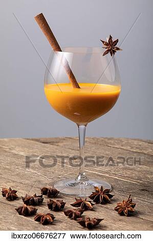 Orange fruity cocktail with cinnamon stick and star anise in a glass, on a wooden table View Large Photo Image Stock Photo - Orange fruity cocktail with cinnamon stick and star anise in a glass, on a wooden table. Fotosearch