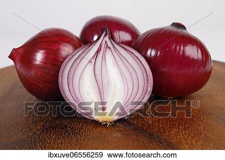 Stock Photo - Red onions (Allium cepa) on wooden board, studio shot, Schleswig-Holstein, Germany, Europe. Fotosearch