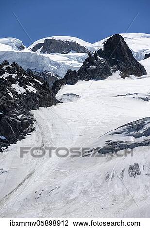 Stock Image - Refuge des Grands Mulets, mountain hut above La Jonction, glacier tongue, Glacier des Bossons, behind Mont Blanc, Chamonix, Haute-Savoie, France, Europe. Fotosearch