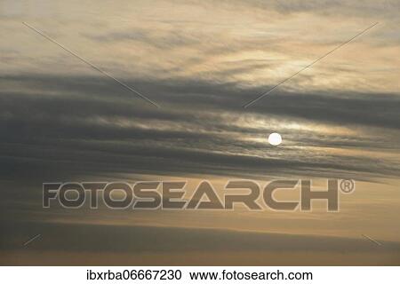 Sun shines behind layered clouds, North Rhine-Westphalia, Germany, Europe View Large Photo Image Stock Image - Sun shines behind layered clouds, North Rhine-Westphalia, Germany, Europe. Fotosearch