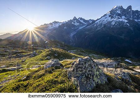 Stock Photography - Sun shines over mountains, Glacier d'Argentière and Aiguille Verte, Mont Blanc Massif, Chamonix-Mont-Blanc, Haute-Savoie, France, Europe. Fotosearch